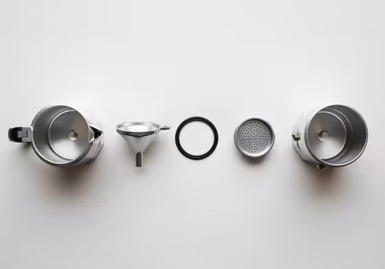 A Brikka Moka pot disassembled into its component parts, laid out neatly for cleaning.