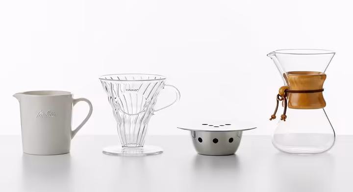 A side-by-side comparison of four popular pour over brewers: the Melitta, Hario V60, Kalita Wave, and Chemex, showing their different shapes and designs.
